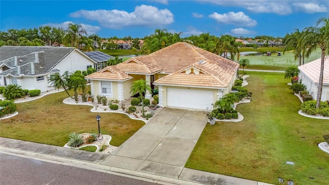 ranch-style home with an attached garage, driveway, a tile roof, and a water view