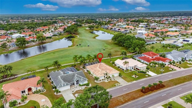 drone / aerial view featuring a water view, golf course view, and a residential view