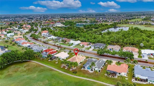 drone / aerial view featuring golf course view, a residential view, and a water view