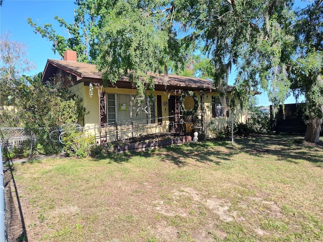 exterior space with a yard, fence, and a chimney