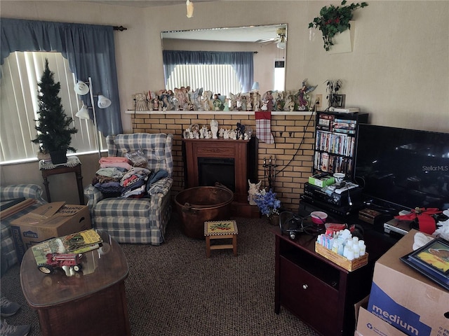 living area featuring ceiling fan, carpet, and a brick fireplace