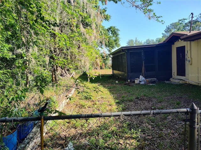 view of yard featuring fence and a sunroom