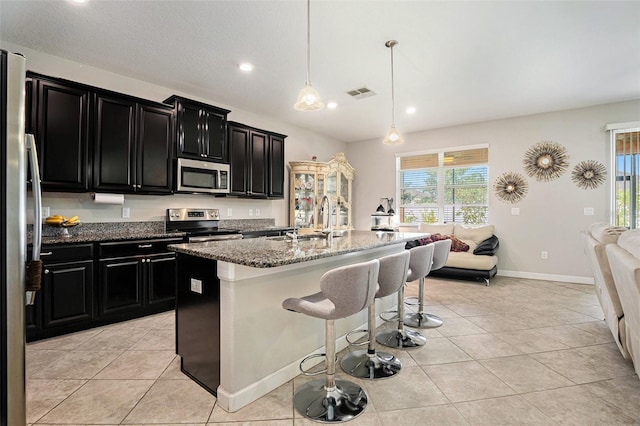 11818 Valhalla Woods Dr, Riverview, FL 33579 - kitchen featuring dark cabinetry, stainless steel appliances, healthy amount of natural light, a sink, and recessed lighting