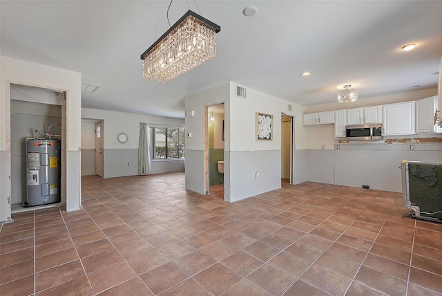 6490 Cape Hatteras Way NE Unit 4, Saint Petersburg, FL 33702 - unfurnished living room with water heater, visible vents, an inviting chandelier, and tile patterned flooring