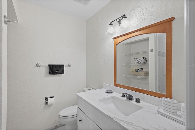 6490 Cape Hatteras Way NE Unit 4, Saint Petersburg, FL 33702 - bathroom with toilet, vanity, and a textured wall