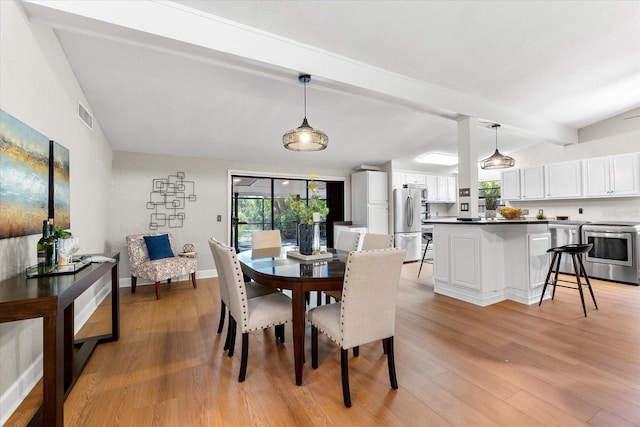dining room featuring beamed ceiling, light wood finished floors, and baseboards