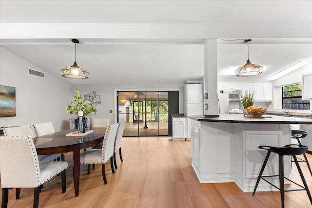 dining area with lofted ceiling and light wood finished floors