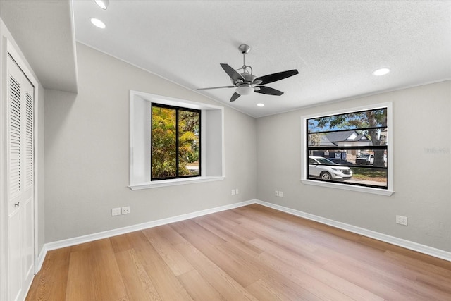 unfurnished bedroom with light wood-style flooring, a closet, lofted ceiling, baseboards, and recessed lighting