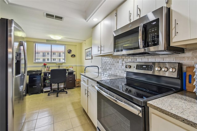 kitchen with white cabinets, visible vents, appliances with stainless steel finishes, light tile patterned flooring, and backsplash