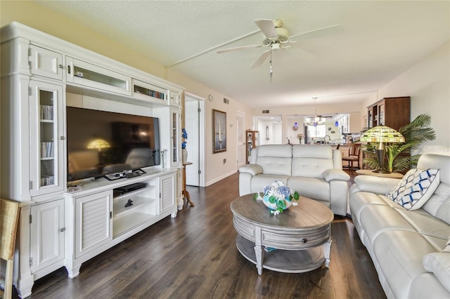 living area featuring dark wood-type flooring, ceiling fan, and a textured ceiling