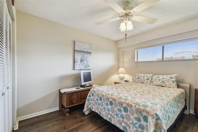 bedroom with dark wood-style flooring, baseboards, and a textured ceiling