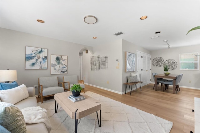 1232 Sedeeva Cir S, Clearwater, FL 33755 - living room with light wood-style flooring, arched walkways, and recessed lighting