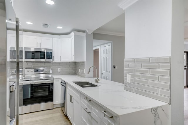 kitchen featuring tasteful backsplash, crown molding, visible vents, appliances with stainless steel finishes, and a sink