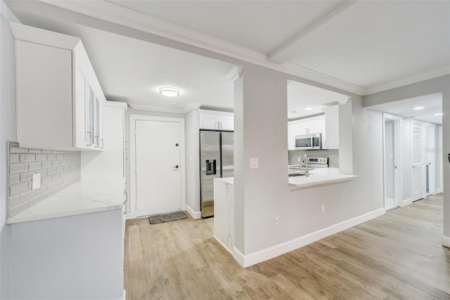 kitchen with light wood-style flooring, ornamental molding, white cabinets, and stainless steel appliances