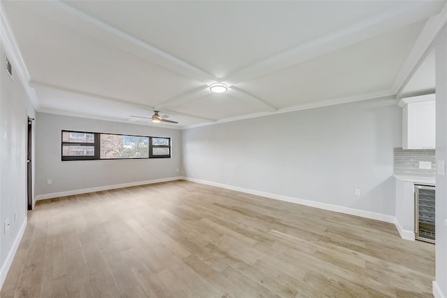 unfurnished living room with light wood-type flooring, crown molding, baseboards, and a ceiling fan