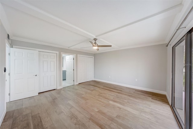 unfurnished bedroom with baseboards, a ceiling fan, crown molding, multiple closets, and light wood-style flooring