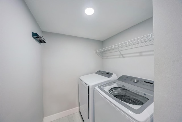 washroom with washing machine and dryer, laundry area, and baseboards