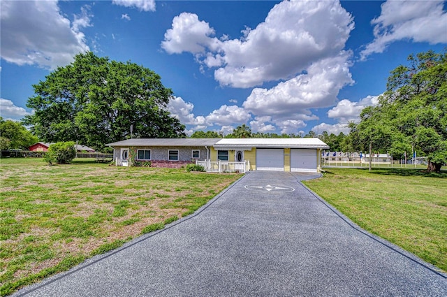ranch-style home with a garage, driveway, and a front lawn