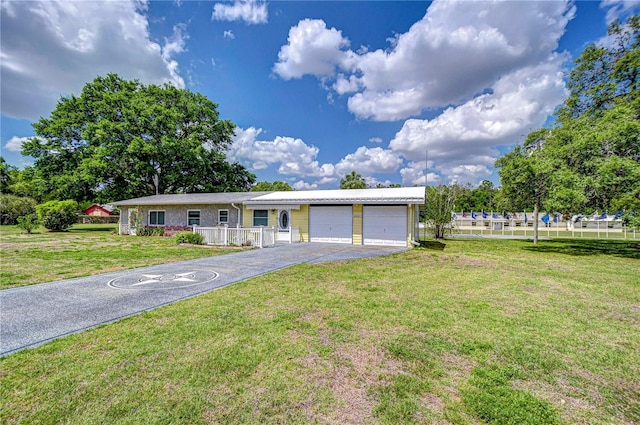 ranch-style home featuring a garage, a front yard, and driveway
