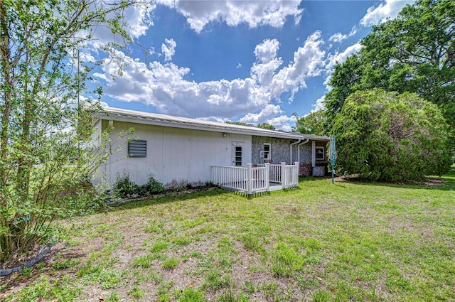 rear view of property featuring a lawn