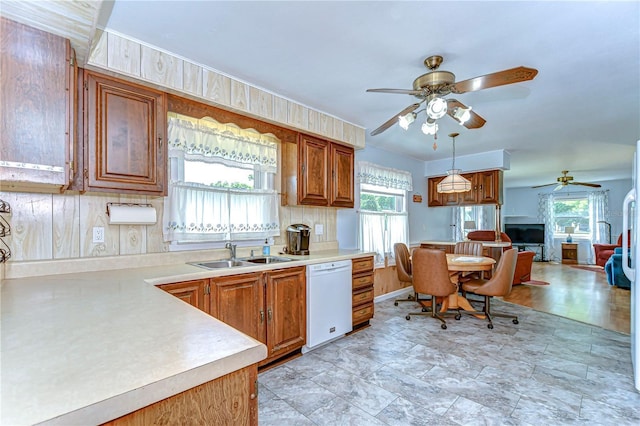 kitchen with a sink, ceiling fan, white dishwasher, and brown cabinets