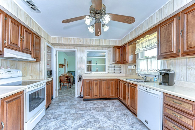 kitchen featuring white appliances, a ceiling fan, under cabinet range hood, visible vents, and a sink