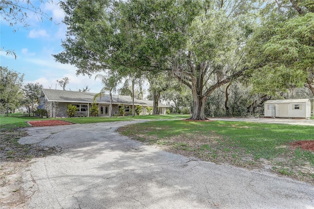 view of front of house with a front yard and an outbuilding