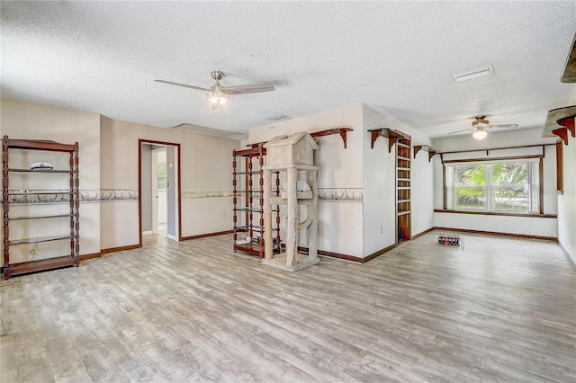 unfurnished room with baseboards, a textured ceiling, wood finished floors, and ceiling fan