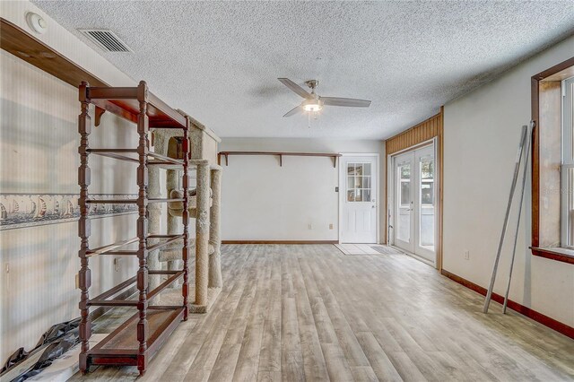 spare room featuring a textured ceiling, wood finished floors, ceiling fan, and visible vents