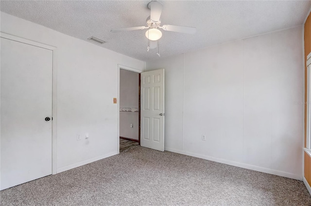 unfurnished bedroom featuring a textured ceiling, ceiling fan, visible vents, and carpet floors