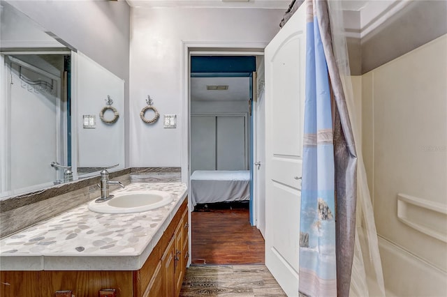 full bathroom with connected bathroom, vanity, and wood finished floors