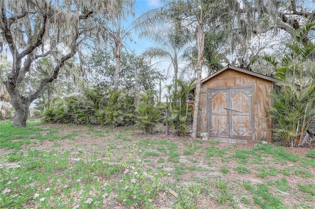 view of yard featuring a storage shed and an outbuilding