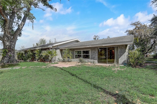 back of property featuring a lawn and stucco siding