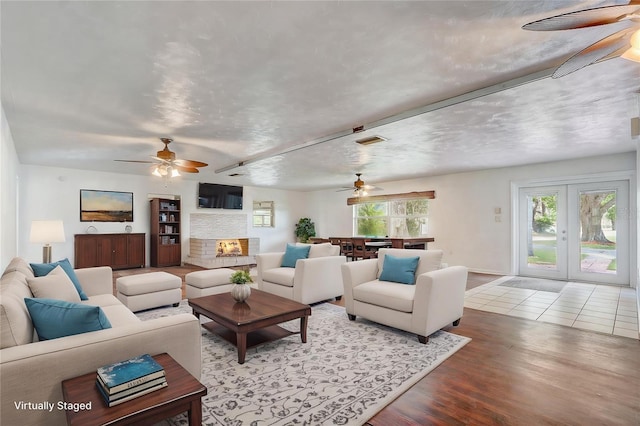 living room with visible vents, ceiling fan, and wood finished floors