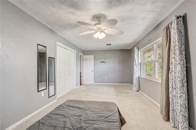 bedroom featuring light carpet, baseboards, and ceiling fan