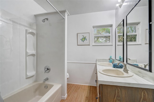 full bathroom with a sink, a wainscoted wall, shower / washtub combination, and toilet