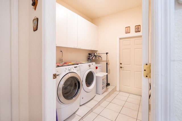 clothes washing area featuring cabinet space, washing machine and clothes dryer, and light tile patterned flooring