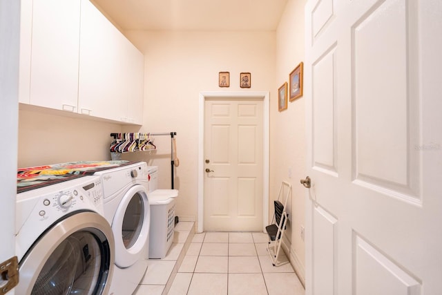 laundry room with washer and dryer, cabinet space, and light tile patterned flooring