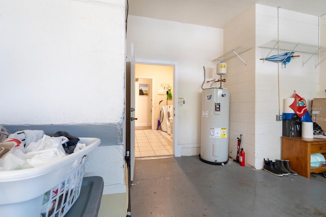 bathroom featuring water heater, separate washer and dryer, and concrete flooring