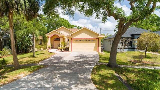 single story home with a garage, a front lawn, driveway, and stucco siding