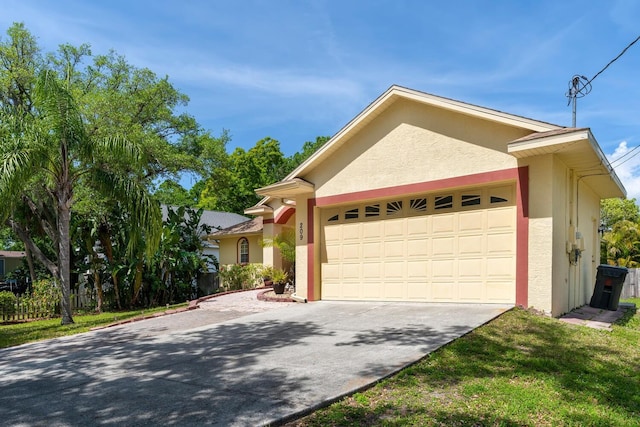 ranch-style house with stucco siding, driveway, and a garage