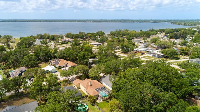 aerial view of property and surrounding area featuring nearby suburban area and a nearby body of water