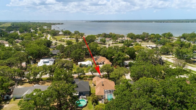 aerial perspective of suburban area with a nearby body of water and a pool