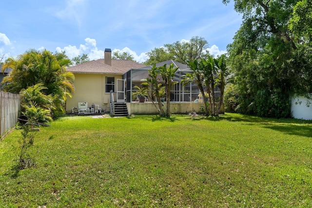 rear view of property with a chimney and a lanai