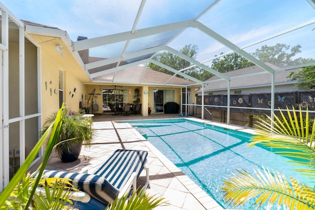 view of pool featuring a patio area, ceiling fan, fence, and a lanai