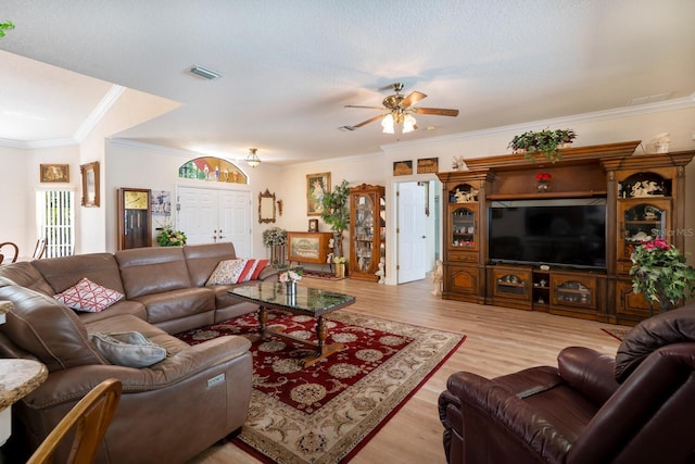 living area with ceiling fan, wood finished floors, and crown molding