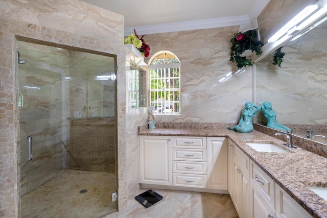 full bath featuring ornamental molding, double vanity, and a shower stall