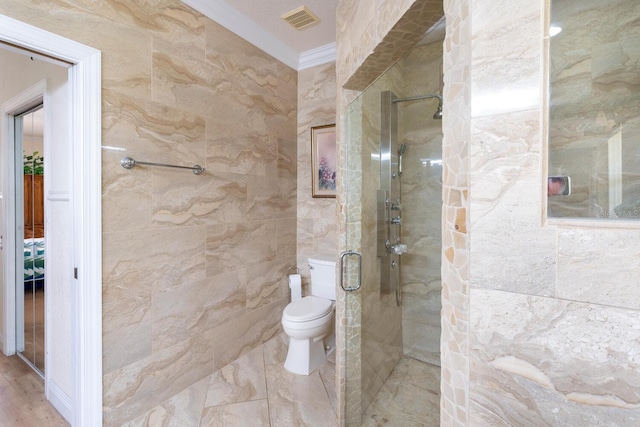 full bathroom with crown molding, tiled shower, toilet, and tile walls