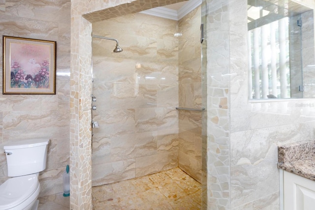 bathroom featuring toilet, tiled shower, tile walls, vanity, and crown molding