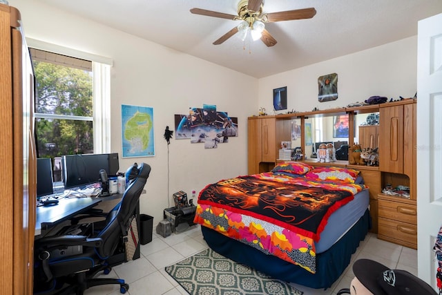 bedroom featuring light tile patterned floors, an office area, and a ceiling fan